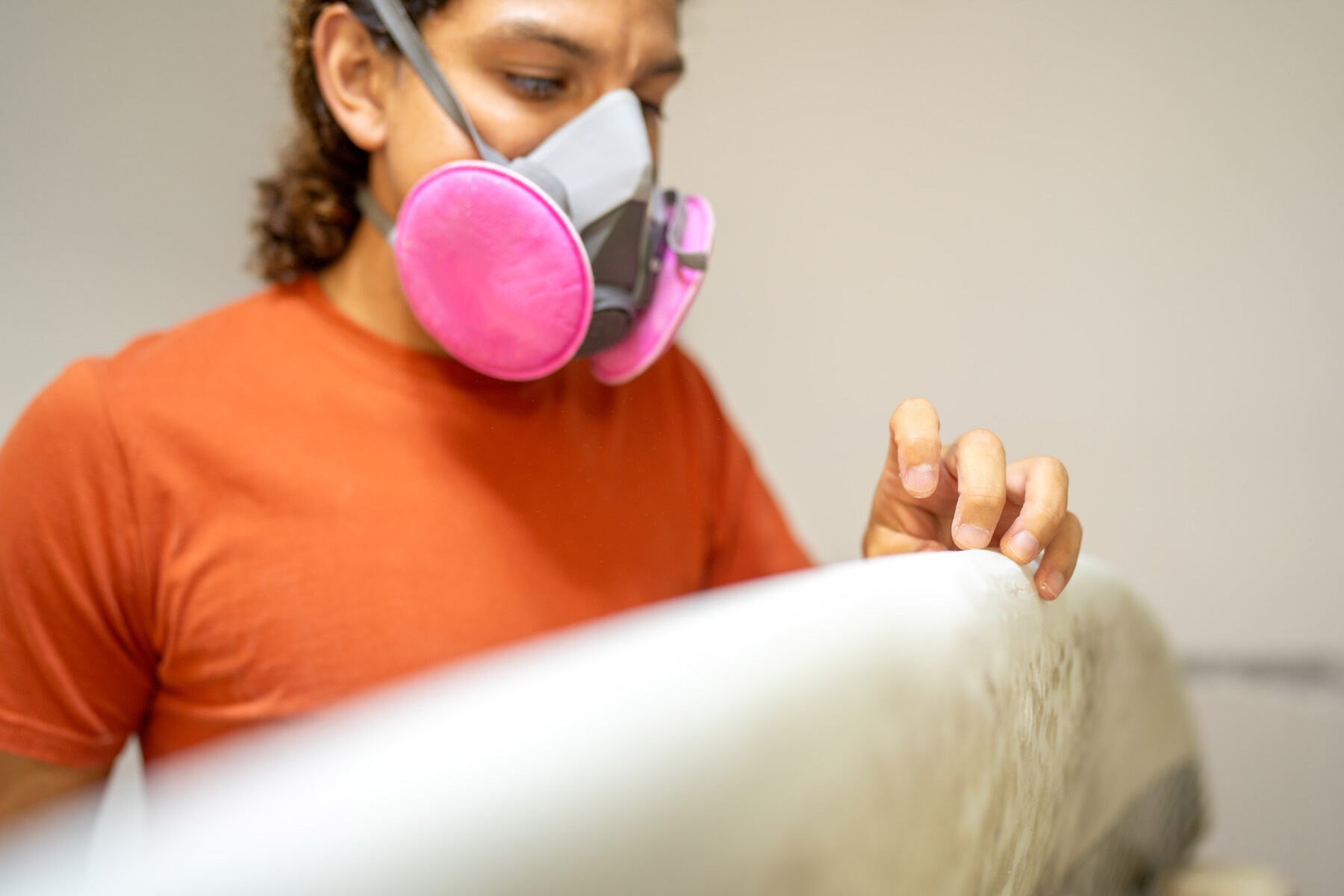 repairman-checking-the-surface-of-a-surfboard-in-a-2024-02-13-19-30-00-utc